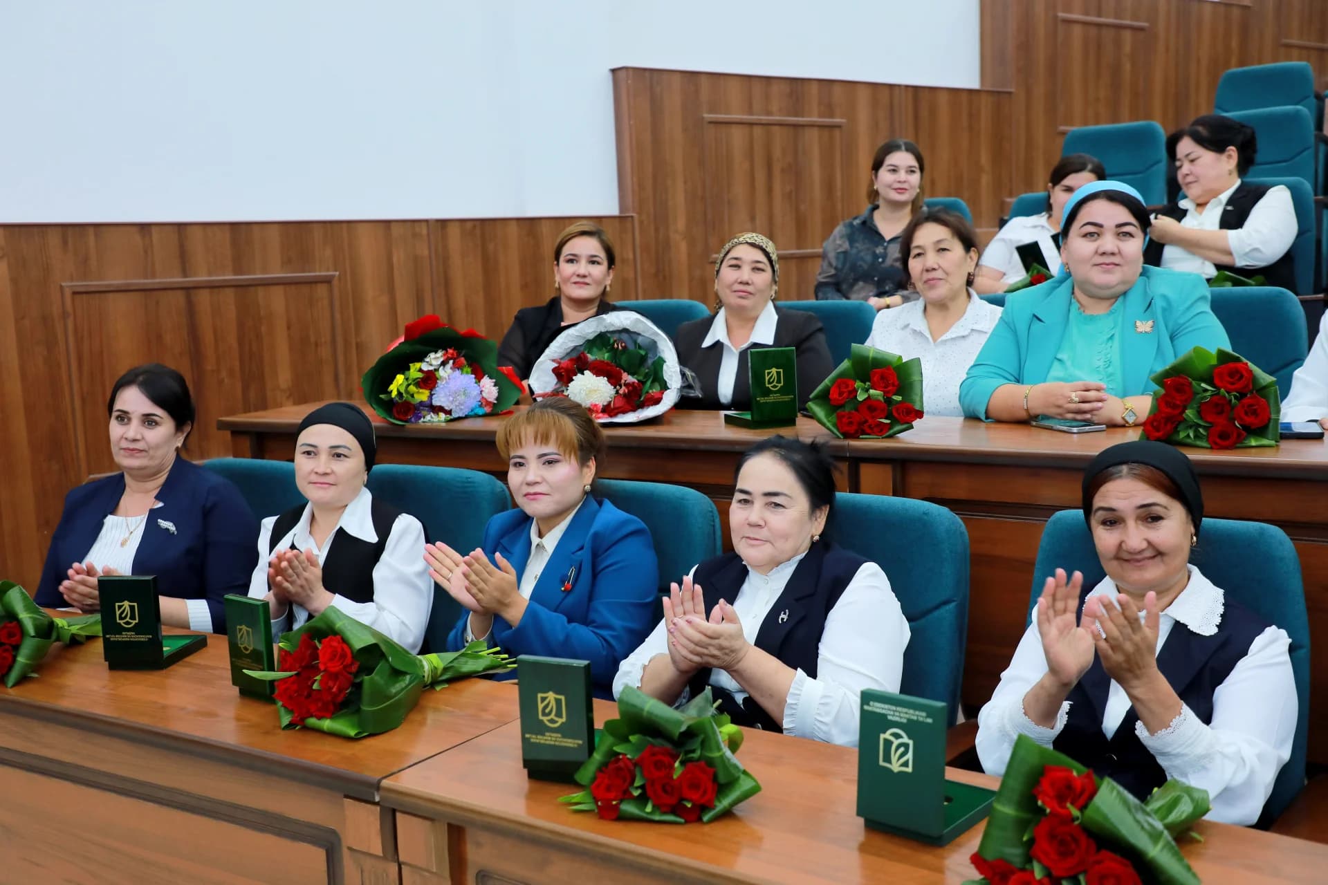 Group of women sitting at desks and applauding
