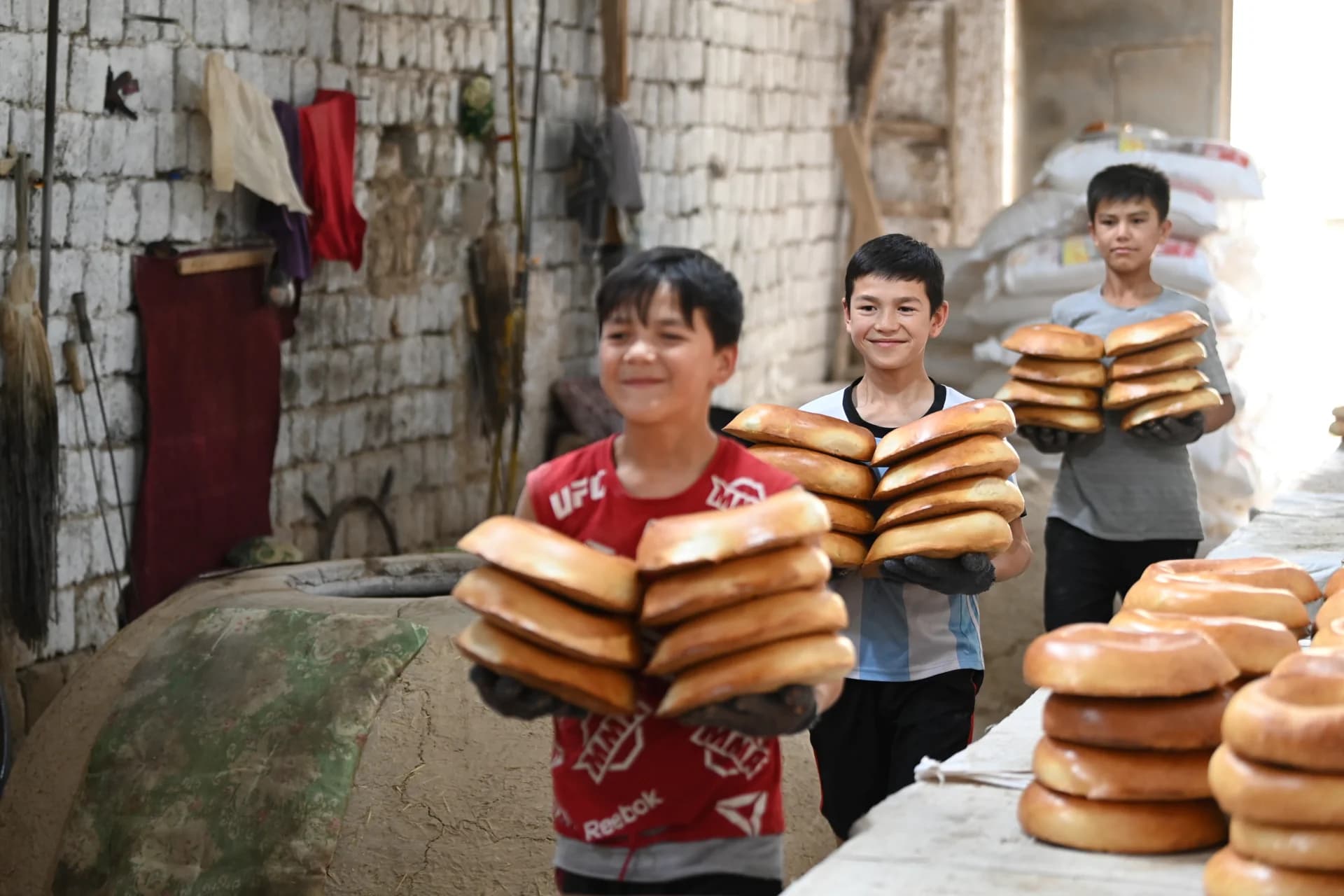 Children carrying freshly baked bread in a bakery