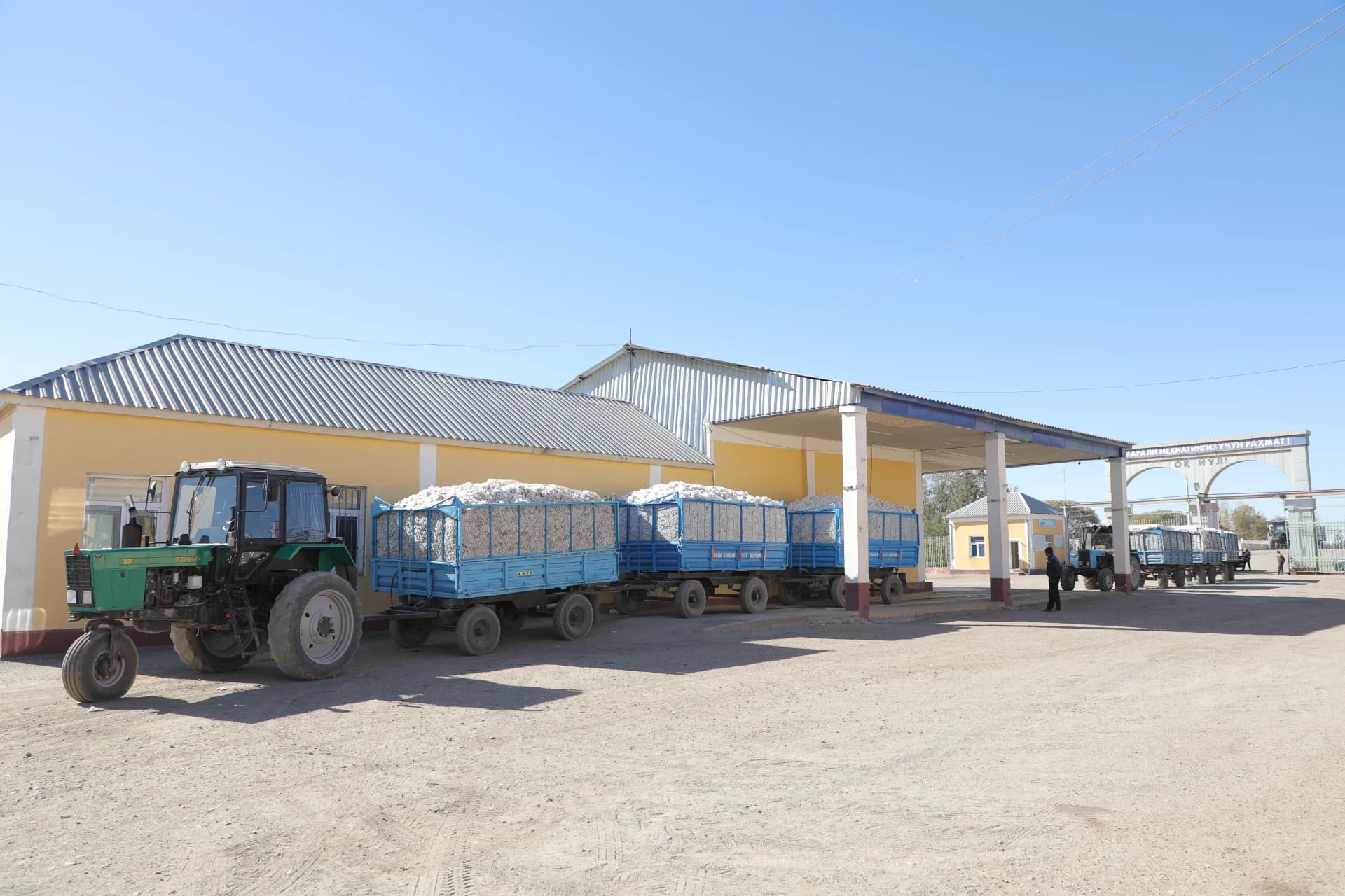 Tractors hauling trailers loaded with harvested material at agricultural site