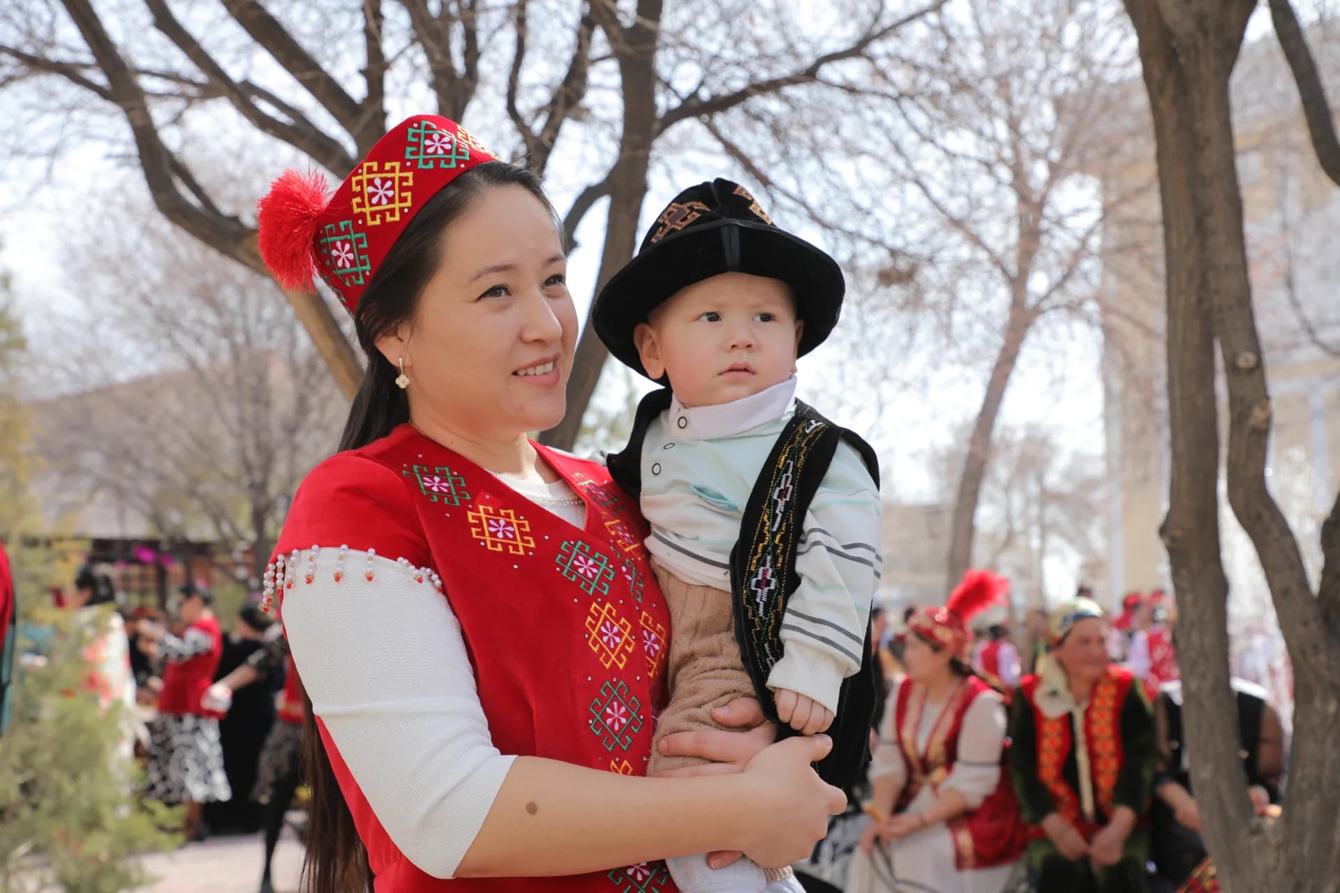 Женщина, держащая ребенка на улице в традиционной одежде