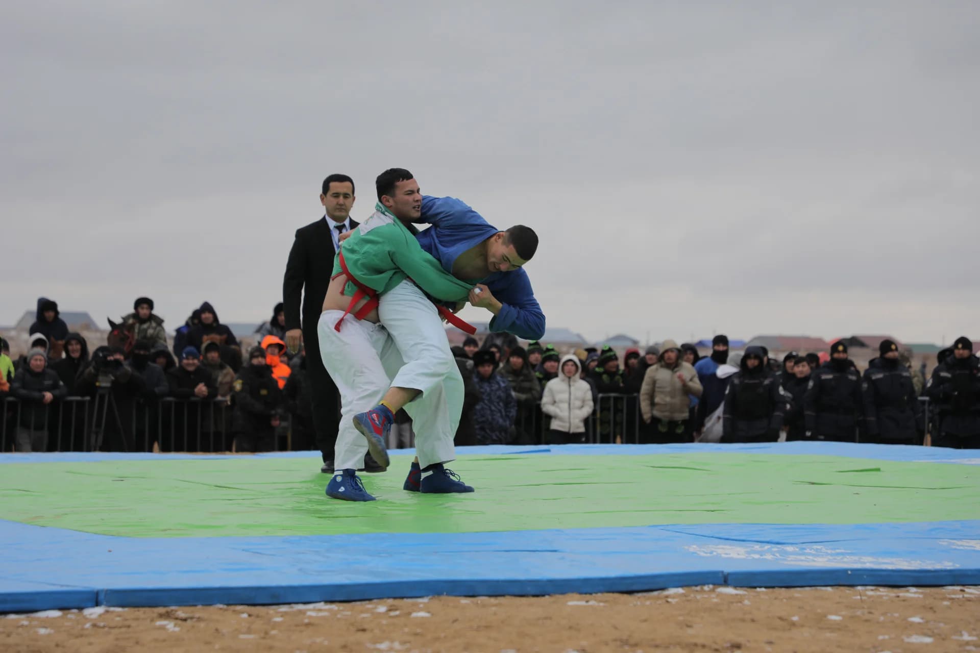 Athletes competing in a wrestling match outdoors