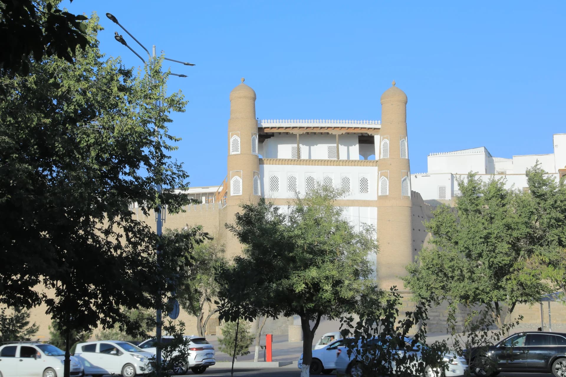 Historic fortress structure with cylindrical towers and white architectural details