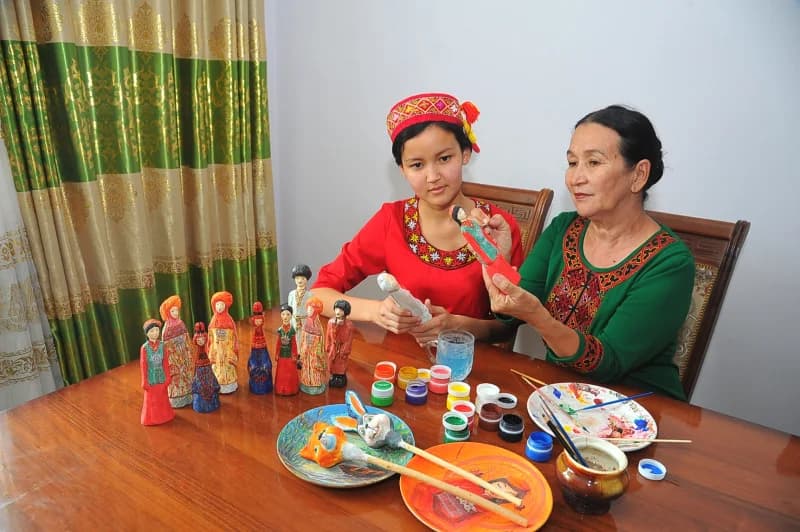 Women painting traditional clay dolls