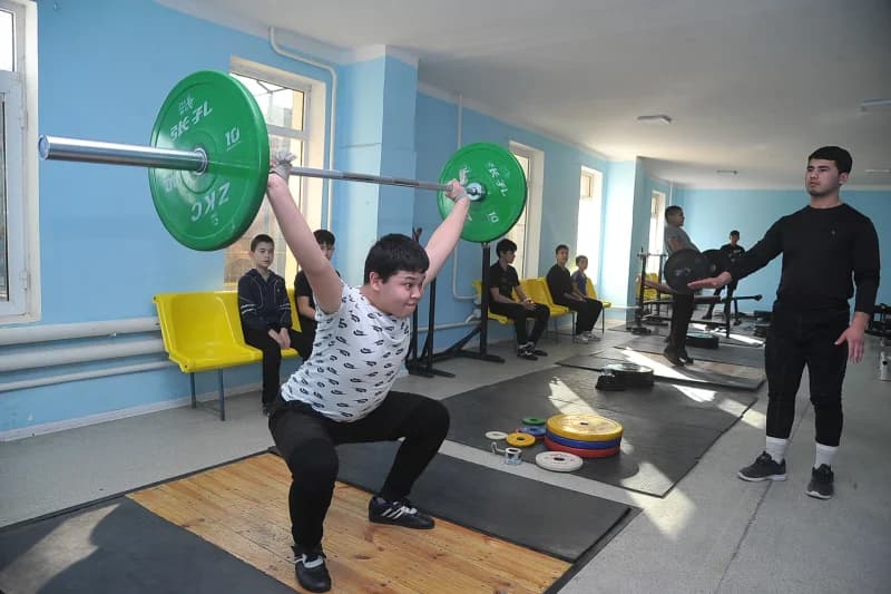 Young athlete lifting heavy barbell