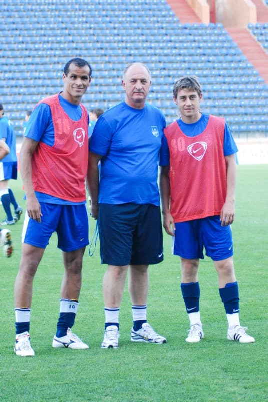 Three men pose on football pitch