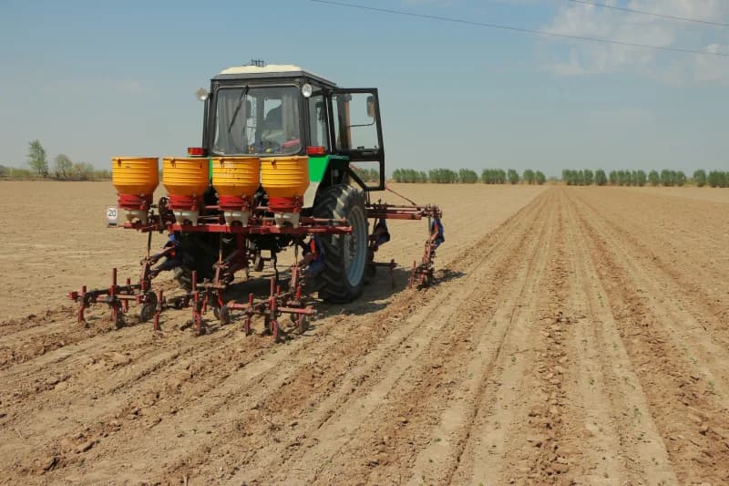 Tractor operates on plowed agricultural field