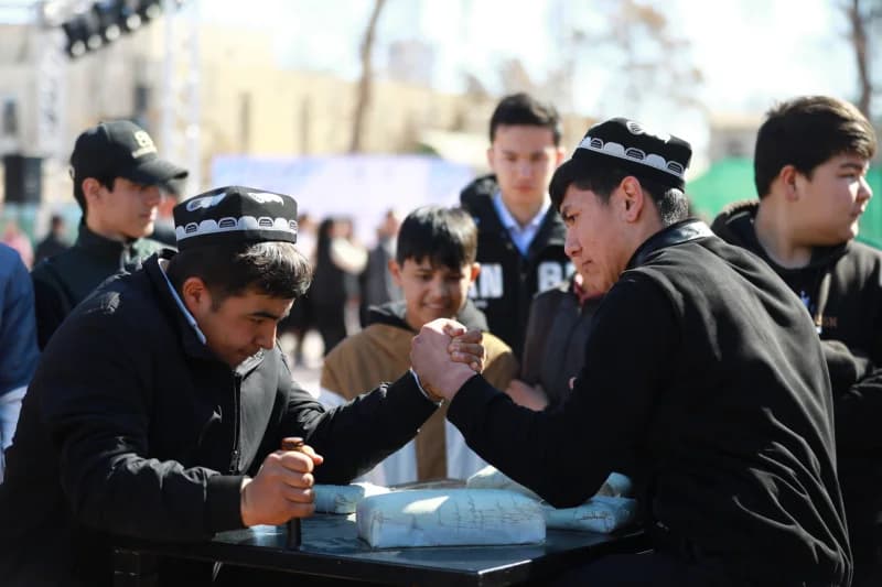 Young men arm wrestling outdoors
