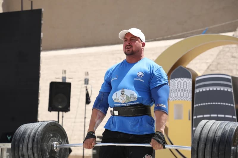 Athlete lifting heavy barbell outdoors