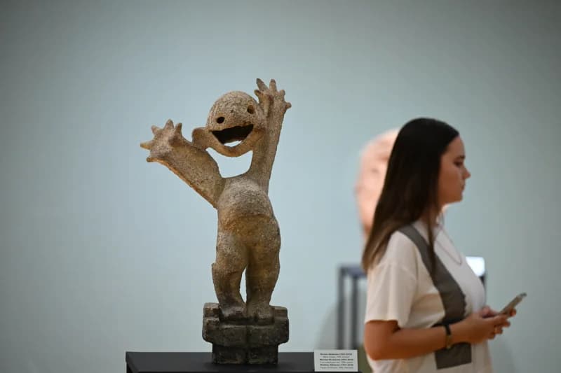 Visitor observing ceramic art sculpture