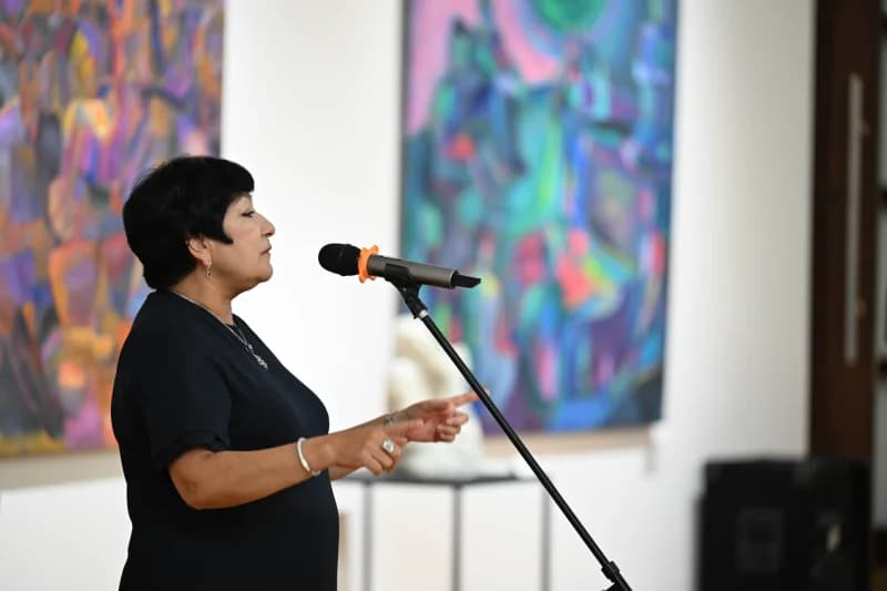 Woman speaking into microphone at gallery