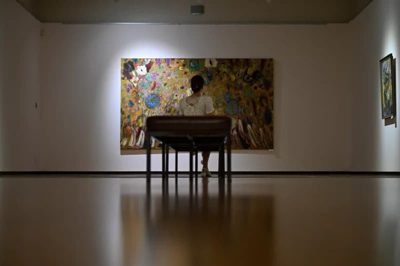 Visitor viewing painting in gallery