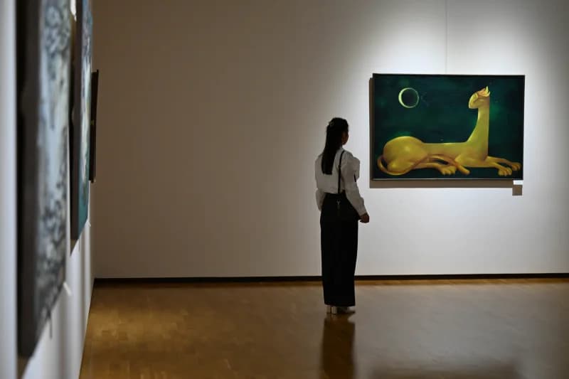 Visitor observing painting inside gallery