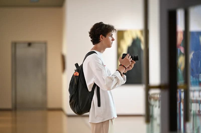 Young man photographing art gallery