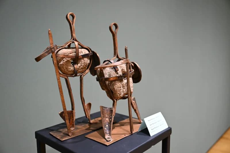 Two metallic sculptures stand on display