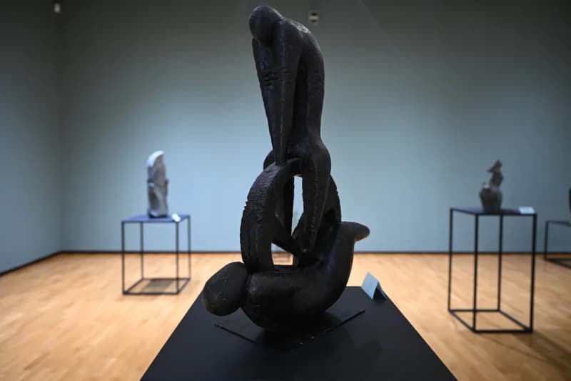 Dark sculpture stands inside museum gallery