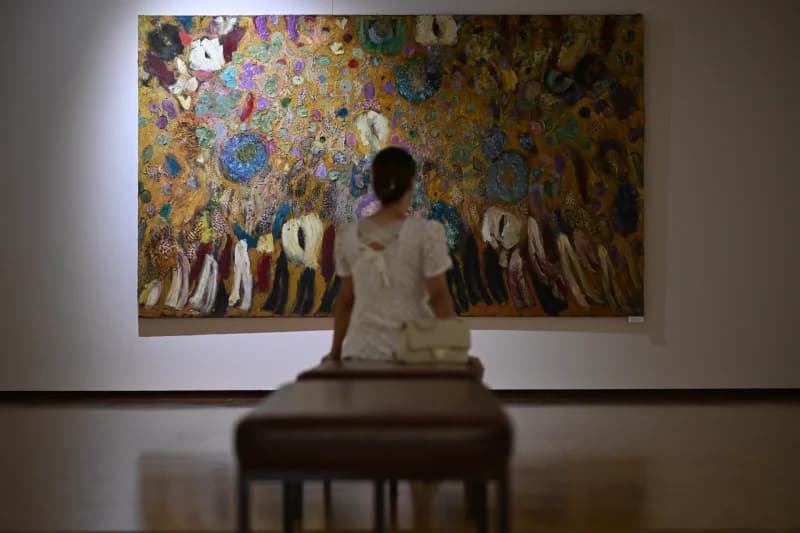 Visitor admiring painting in gallery