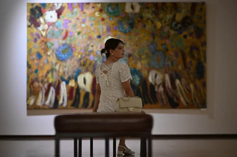 Woman viewing painting in gallery