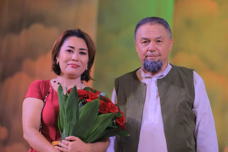 Qoʻllarida atirgul tutgan erkak va ayol