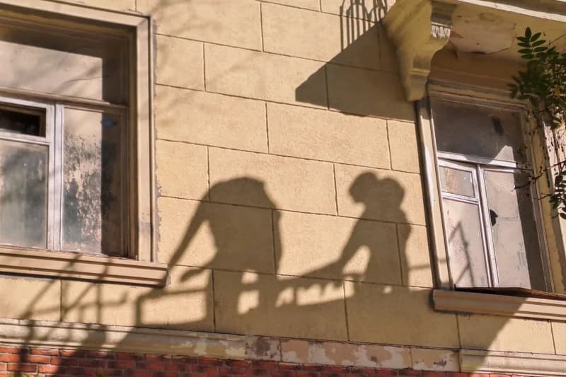 Shadows of people on a building wall