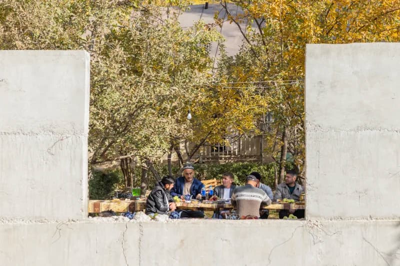 People gathered around a table outdoors in an outdoor setting