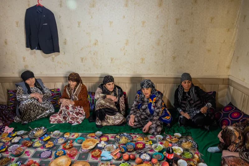 Group of women gathered around a traditional spread of food indoors