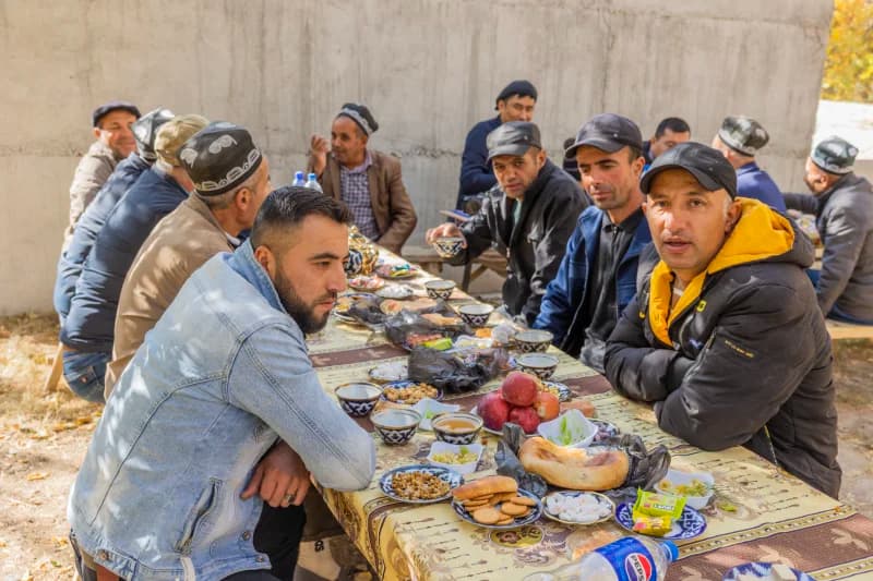People gathered around a long table outdoors for a meal