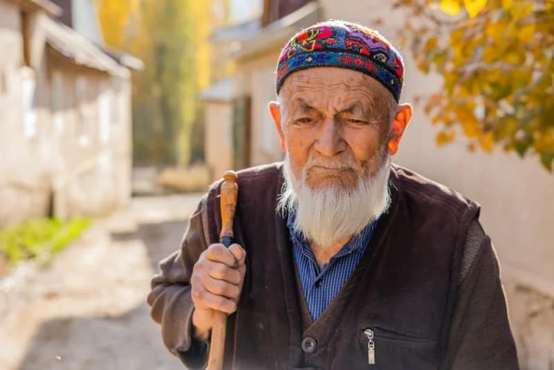 Пожилой мужчина стоит на улице