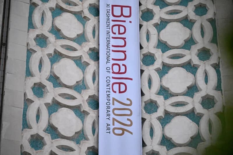 Art exhibition banner on an ornate patterned wall