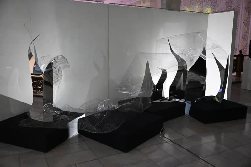 Modern art sculptures displayed on black pedestals indoors